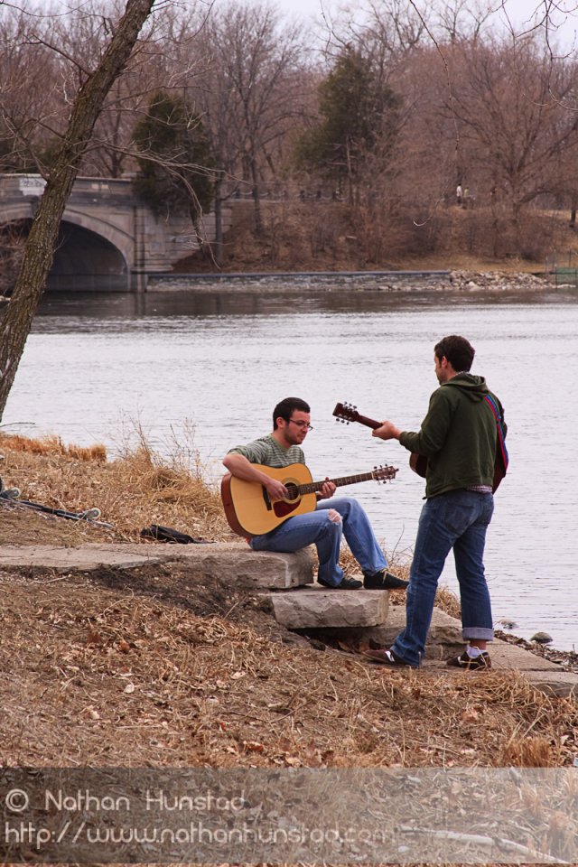 Two guitar players around Lake of the Isles.
